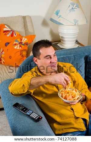 Relaxed guy watching television at home in the evening
