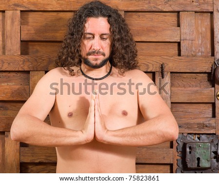 Long haired guy in contemplative attitude indoors