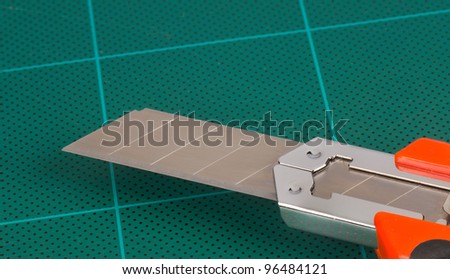 Cutter blade on a green cutting board