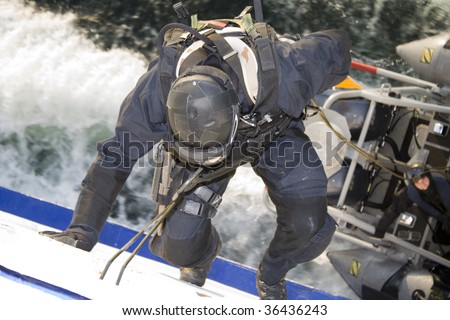 KIEL, GERMANY - JULY 1 : German special forces agent climbs down into a moving boat during training mission July 1, 2009 in Kiel, Germany.