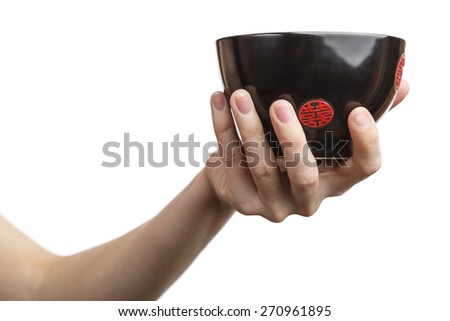 Female hand holding a black mug Japanese. Isolated on white background.Alpha