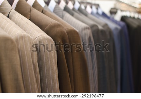 Men suits hanging in a clothing store.