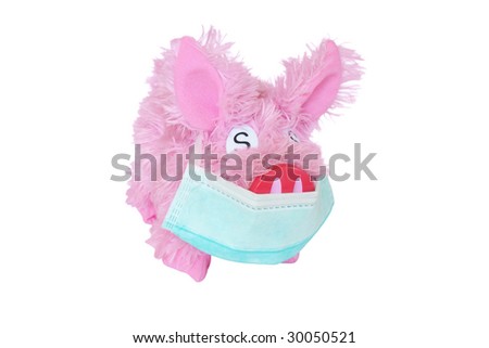 Pink toy pig with earloop mask isolated on white background. Anti swine flu concept.