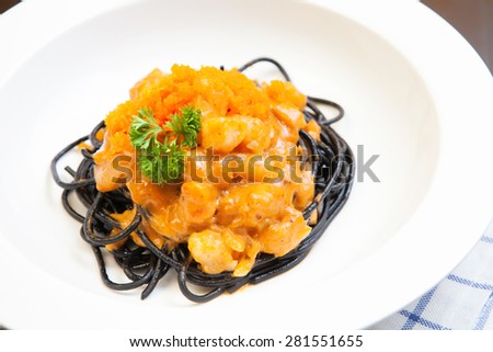Black spaghetti, pasta with salmon and red caviar in sauce, italian cuisine