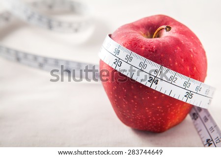 Fresh red apple core and measuring tape. Diet concept