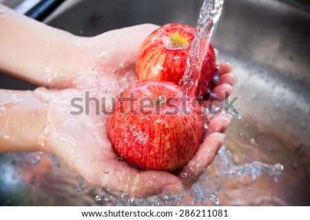 Red apple with water splash on hands, Fresh an Healthy foods concept