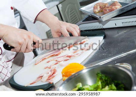 Chef hand slice bacon for steak menu