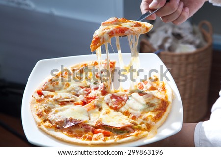 Homemade Pizza lifted slice on chef hand