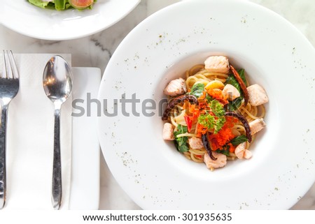 Fried pasta with salmon on marble table, Top view