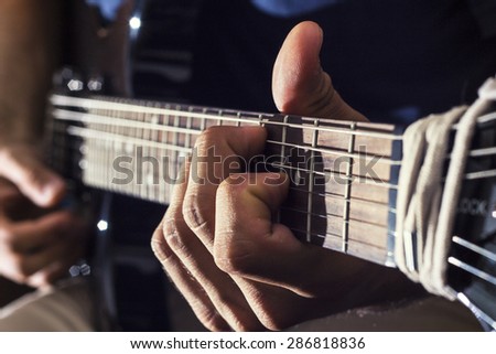 man plays electric guitar with his special techniques under the flash light