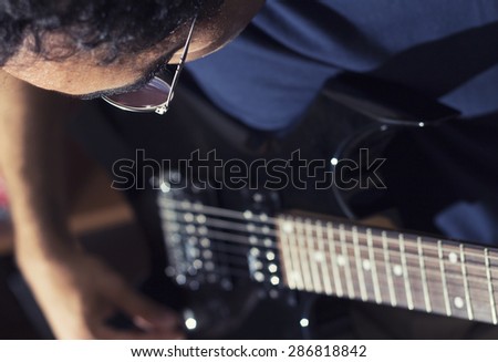 man plays electric guitar with his special techniques under the flash light