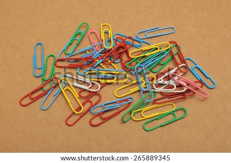 Set of color paper clips on brown paper background