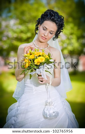 portrait of beautiful young bride in garden .Play with bouquet