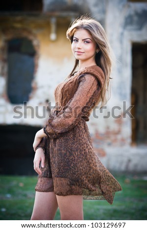 Romantic young woman posing outdoor in the field.Verry attractive woman posing in front of farm