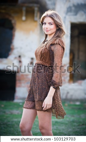 Romantic young woman posing outdoor in the field.Verry attractive woman posing in front of farm