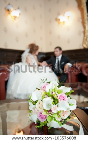 wedding details - young marrieds behind a wedding bouquet in a room