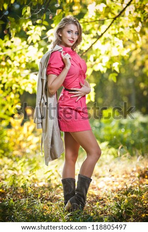 Beautiful elegant woman in autumn park .Young pretty woman at the autumn park. Beautiful woman spending time in park during autumn season .Young pretty woman at the autumn park