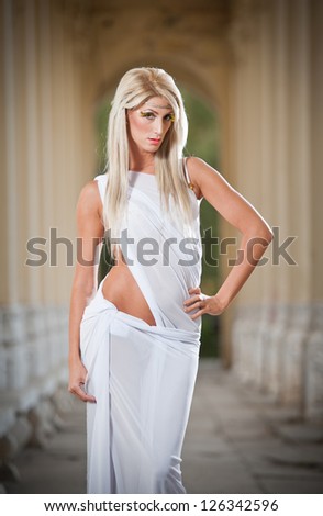 Beautiful blonde angel with  white veil posing outdoor.Sweet angel . young blond haired woman with white wings like an angel .Beautiful angel woman
