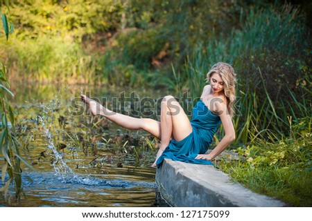 young women in a blue long dress at sunset in a forest .Beautiful young woman in blue dress in garden on sunset . pretty young blonde in a teal green prom dress outdoors in a field