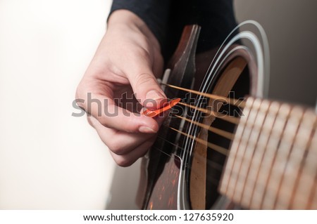 Female hand playing acoustic guitar.guitar play.Close up of guitarist hand playing acoustic guitar