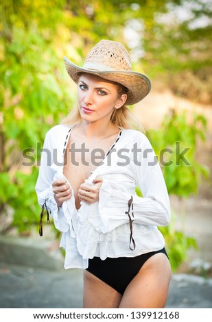 fashion portrait woman with hat and white shirt in the autumn day.Very cute blond woman outdoor with a hat in a autumn forest