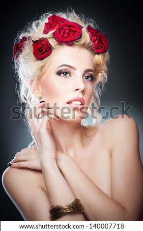 Hairstyle - beautiful sexy female art portrait with roses.Elegance. Genuine Natural Blonde Bride with red Flowers. Artistry.Portrait of a beautiful blonde woman with flowers in her hair. Fashion photo