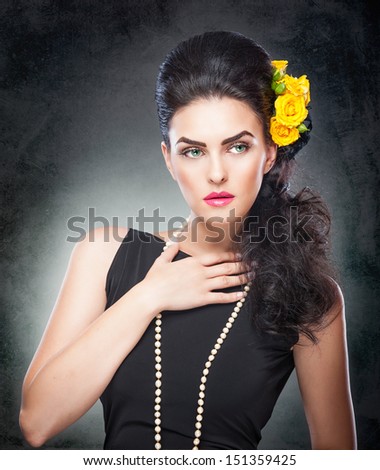Hairstyle and Make up - beautiful female art portrait with yellow roses and beads.Elegance. Natural brunette with Flowers. Portrait of a attractive woman with beautiful eyes and flowers in her hair.