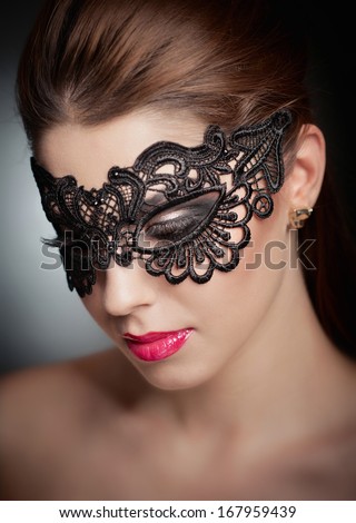 Portrait Of Attractive Sensual Young Woman With Mask. Young Attractive Brunette Lady Posing On Grey Background In Studio. Portrait Of The Beautiful Fashion Sexy Woman With Red Lips And Mask Indoor