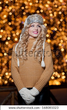 Fashionable lady  Wearing Cap And muffler Coat outdoor .Portrait of young beautiful woman in winter style.Bright picture of beautiful blonde woman with make up