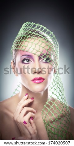 Professional make up - beautiful female art portrait with beautiful eyes. Elegance. Genuine natural woman with veil in studio. Portrait of a attractive woman with red lips and creative make up