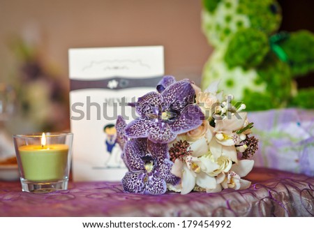 Wedding decorations with candle. Floral arrangements on wedding ceremony detail. Elegant wedding arrangement with flowers, candle and card