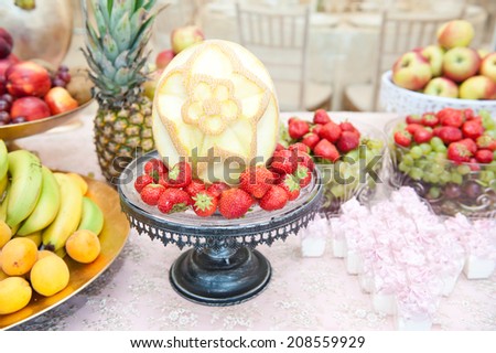 Fruits arrangement. Fresh various fruits elegant decoration. Assortment of exotic fruits. Multicolored fruits. Wedding decoration with fruits on restaurant table, pineapple, bananas, nectarines, kiwi