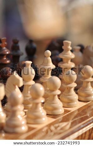 Black and white chess pieces on a chessboard, closeup. Set of chess figures on the playing board