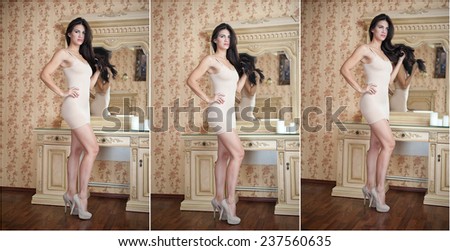 Charming young brunette woman in tight fit short nude dress in front of a mirror. Sexy gorgeous long hair girl near vintage wall mirror. Full length portrait of sensual female posing provocatively.