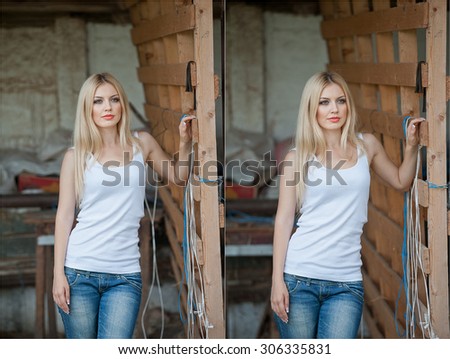 Shot of beautiful girl near an old wooden fence. Stylish look wear: white basic top, denim jeans. Country style farmer. Beautiful long hair blonde in rustic style