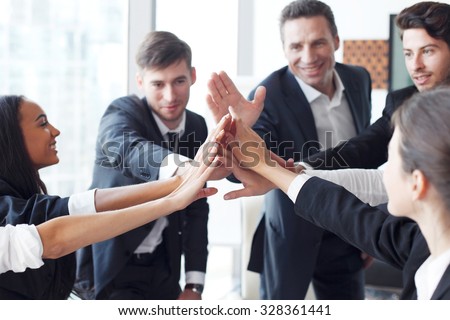 Happy business team making high five with their hands in the office