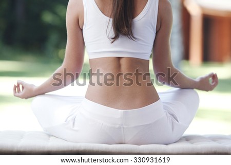 Close-up of young woman doing yoga exercise in the park