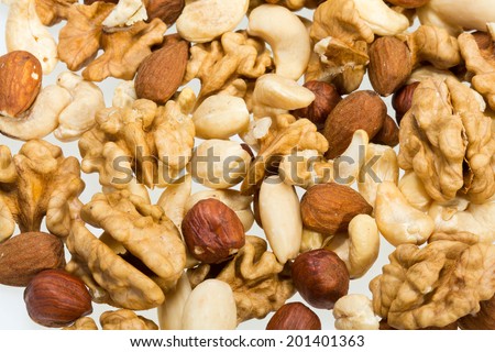 mixed nuts  -  hazelnuts, walnuts, cashews,  pine nuts isolated on white background