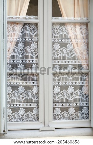 The white window with decorative old lace curtains