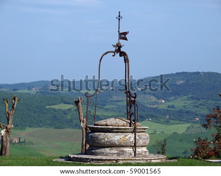 old well on the background of the Tuscan landscape
