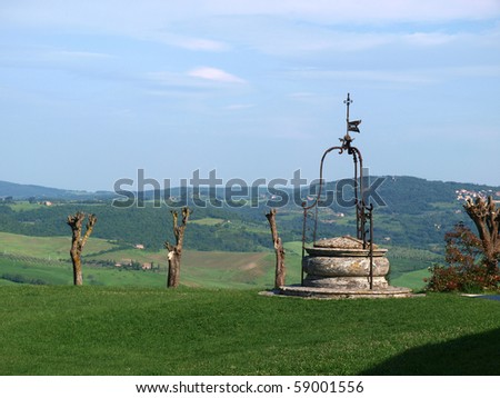 old well on the background of the Tuscan landscape