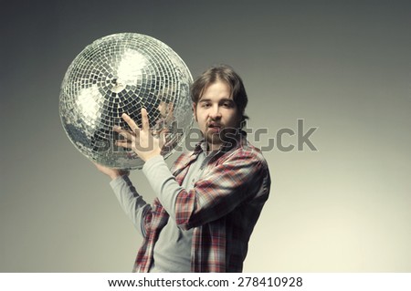 Young man posing with a disco ball. And making a silly face.