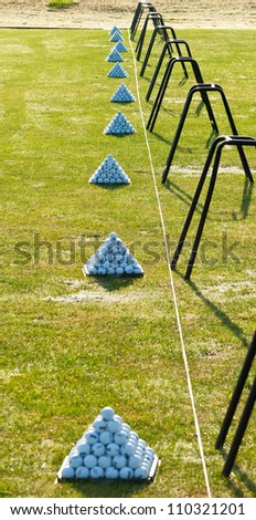 Stack of golf balls lined up at driving range