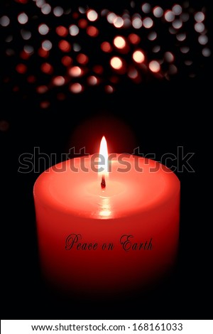 Candle burning with soft bokeh lights in background, Peace On Earth text