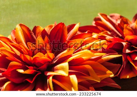 Silk flowers in autumn colors against a soft green background