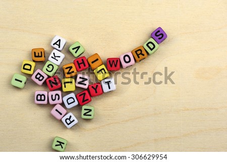 Many colorful blocks with letters which finally form the word words, on light wooden background.