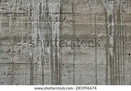 Concrete wall with wooden pattern impress from wooden form board shuttering and with sags of cement concrete