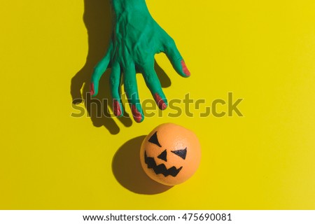 zombie\'s hand is trying to get jack o\'lantern. Halloween concept. special scary shadows