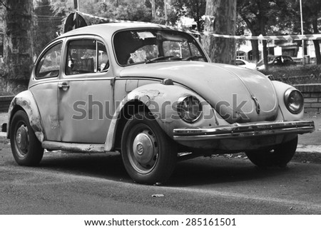 MILAN, ITALY-AUGUST 9, 2014: German motor car Volkswagen Beetle Parked in the city black and white.