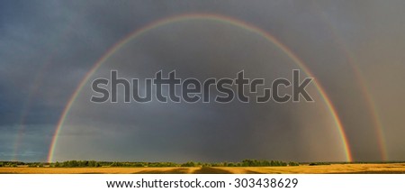 Rainbow over field. Russian nature